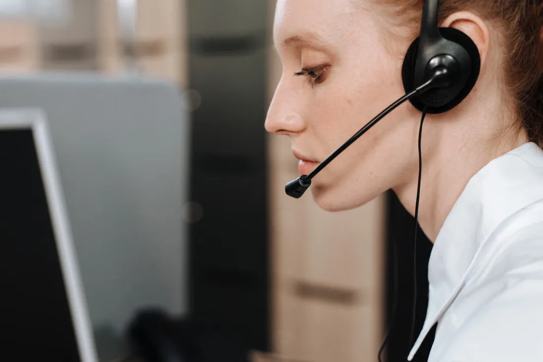 A customer service agent wearing a headset at a desk