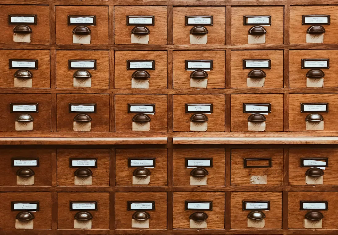 A wall of labelled wooden card index drawers in a library catalogue