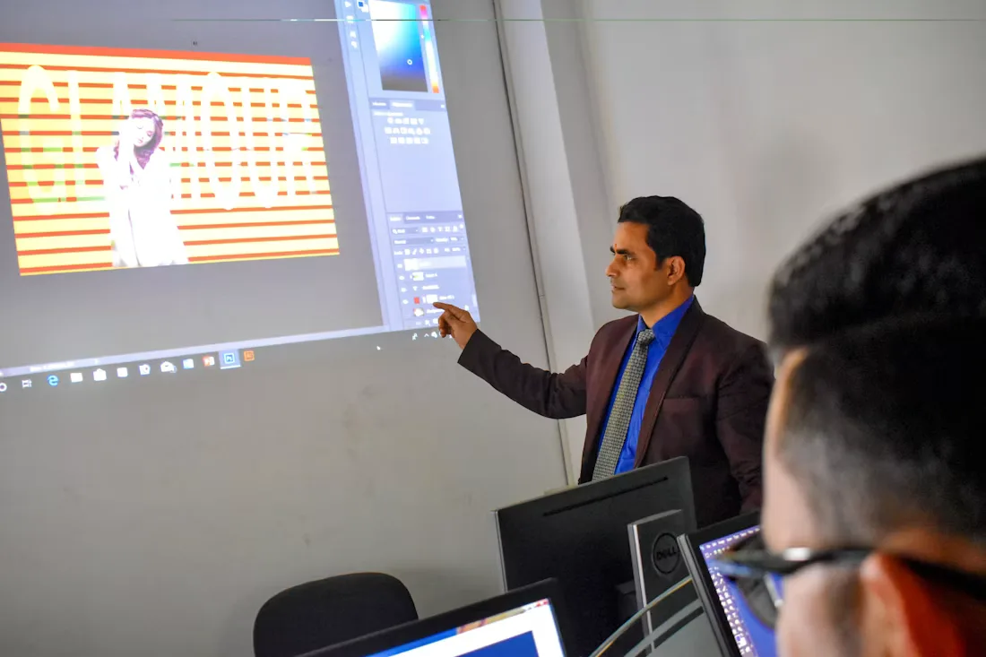 A presenter standing beside a projected slide deck during a training session