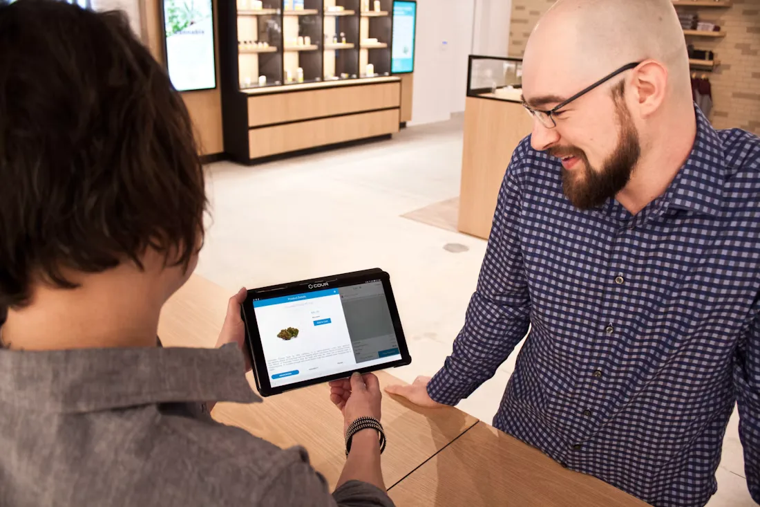 A staff member showing a product on a tablet to a customer in a store